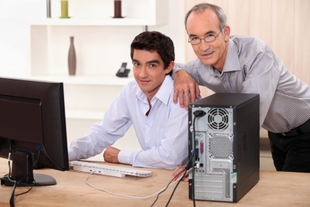 Baby boomers and millennials: colleagues working on a PC