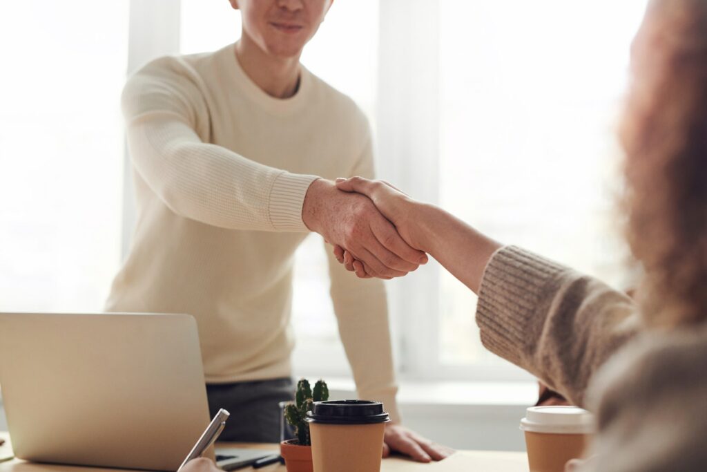 Finding the right talent for your business - Man and woman shaking hands across a table