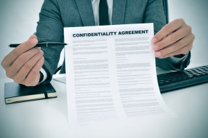 Why use a non-disclosure agreement? - a young man showing a confidentiality agreement document