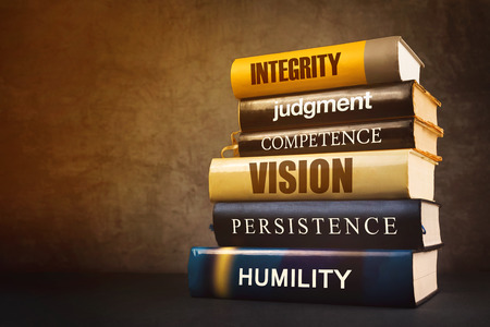 business leader qualities with stack of books based on humility