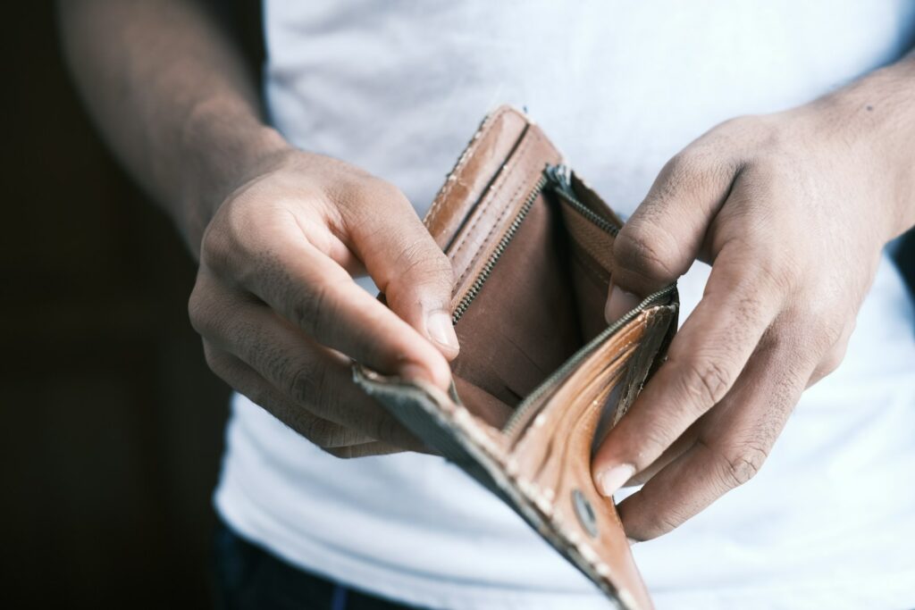 Navigating cash flow problems - person holding empty brown leather wallet