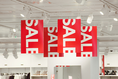 Getting rid of slow moving stock - sale signs in a clothing store hanging from the ceiling