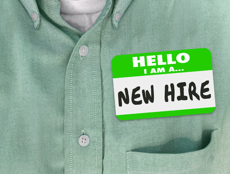 7 common induction mistakes - new hire name-tag on a green shirt worn by a new employee