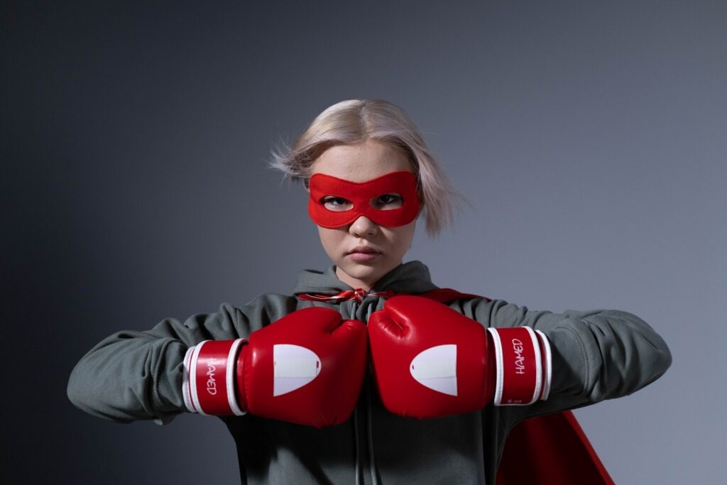 Why SME business owners wear the superhero hat - Photo of a Girl in Red Mask Wearing Boxing Gloves