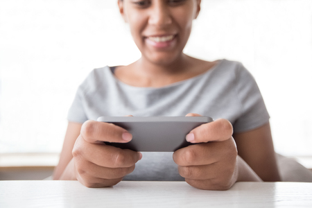 Is technology making you less efficient? - smiling woman playing video game on smartphone