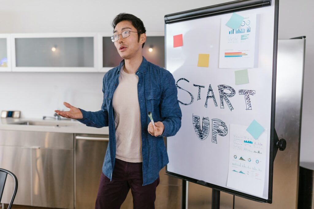 10 key concepts every small business owner needs to understand - Man in Blue Denim Jacket Standing Near the White Board
