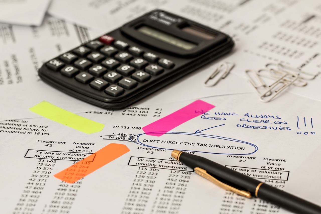 Avoid These 5 Costly Accounting Mistakes - a calculator and pen on top of annotated accounting records