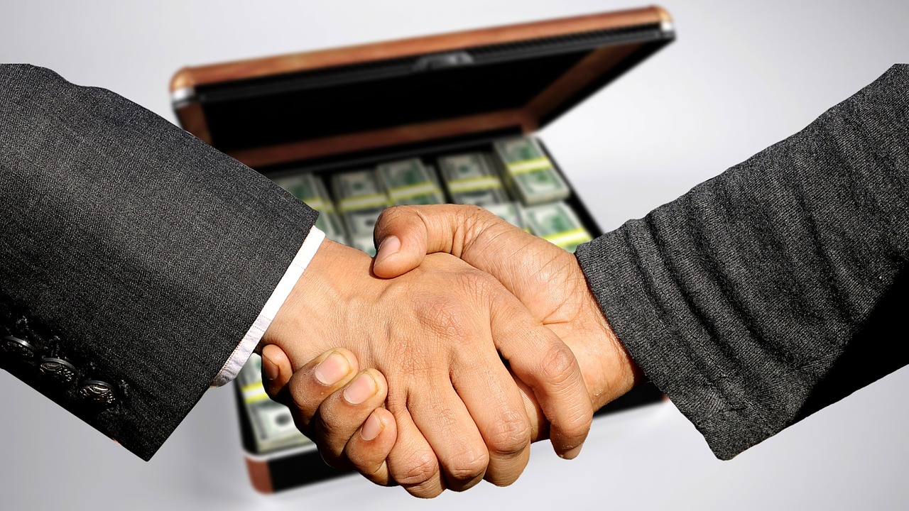 How to build a business to sell - two men shake hands over a case full of cash