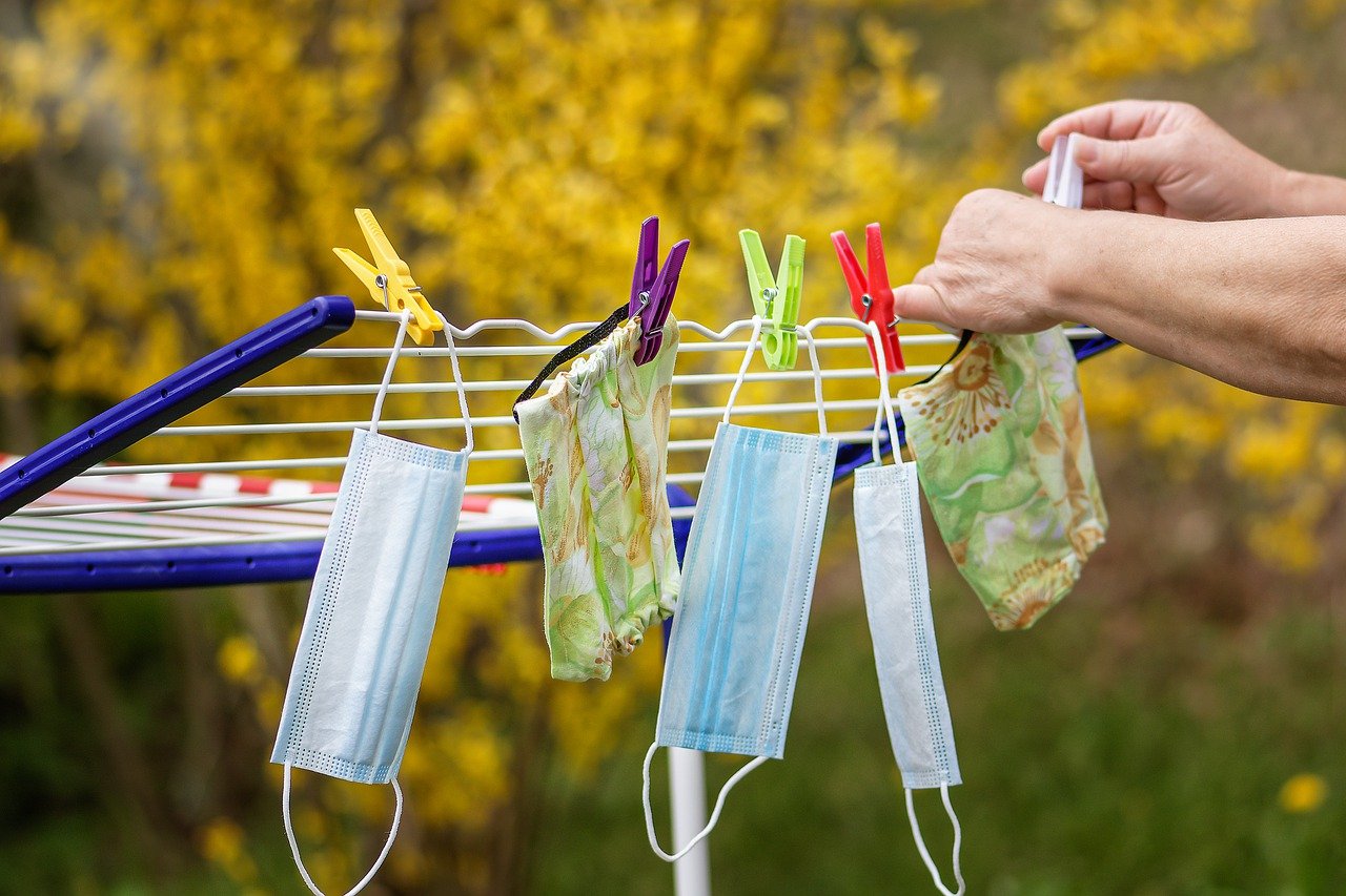 COVID-19 Business Update – 22 October 2020 - a person is pegging single-use face masks onto a washing line to dry