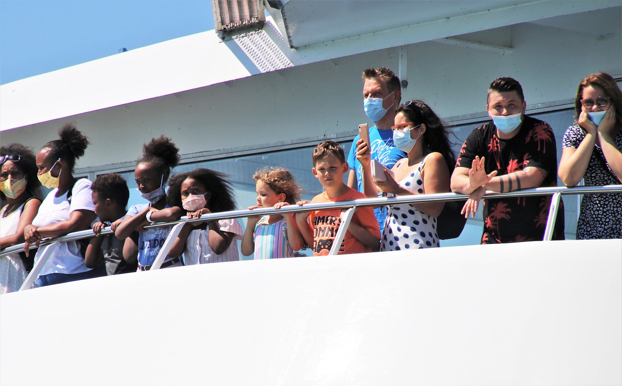 Business update 6 May 2021 - people wearing face masks stand at the railing of a ferry