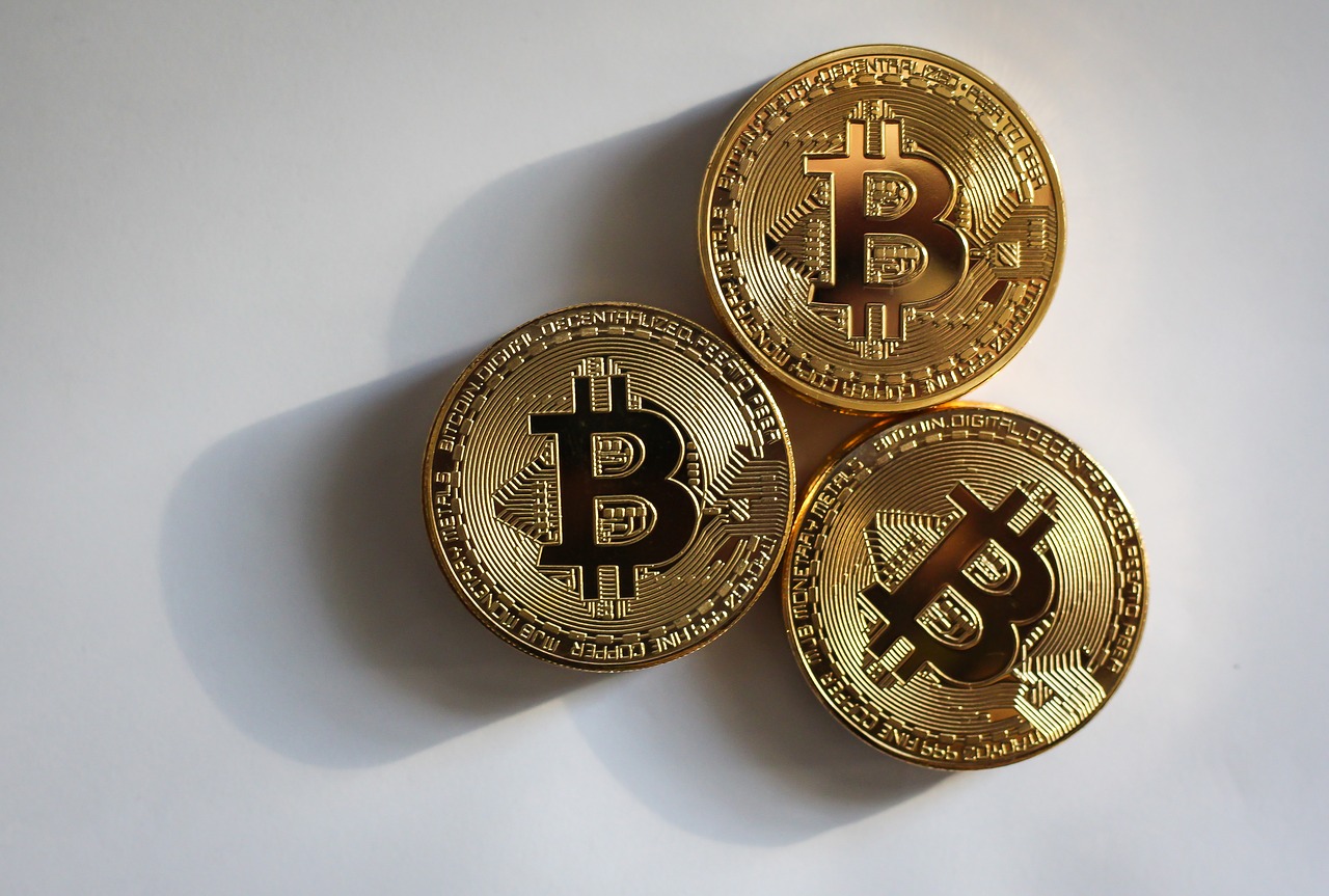 Tax Implications of Cryptocurrencies - three gold coins with the Bitcoin logo