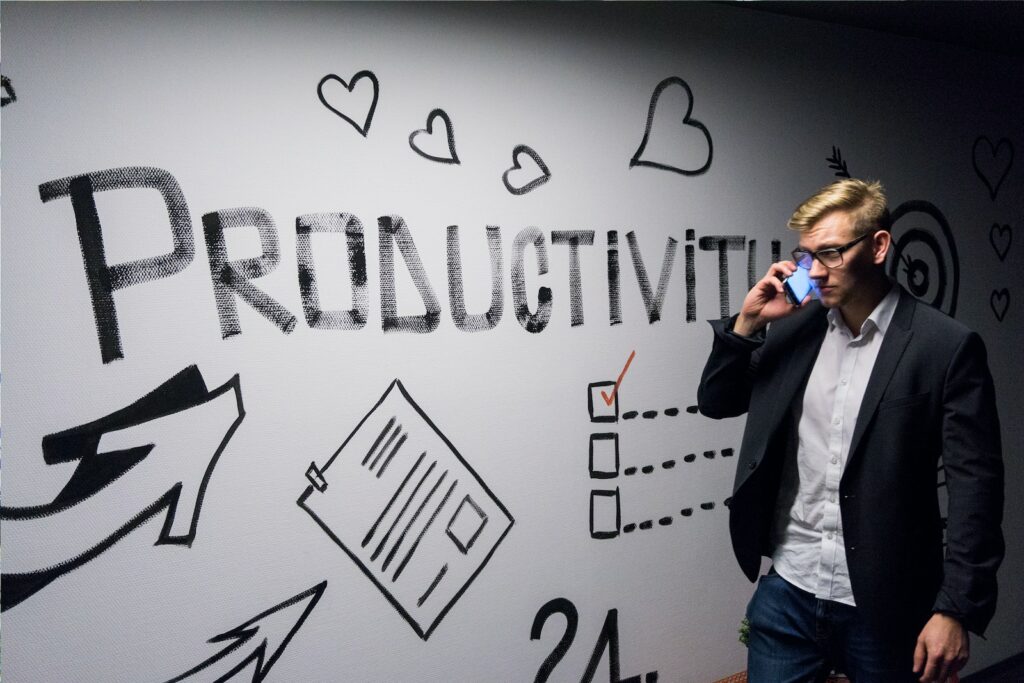Business Update – 5 October 2023 - man holding smartphone looking at productivity wall decor