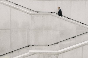 Grow your business without borrowing - business growth concept - businessman climbing up white marble stairs