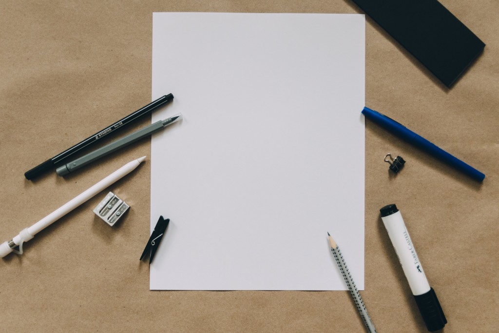 How to get professional business stationery on a tight budget - pens, pencils and markers surrounding a sheet of white paper