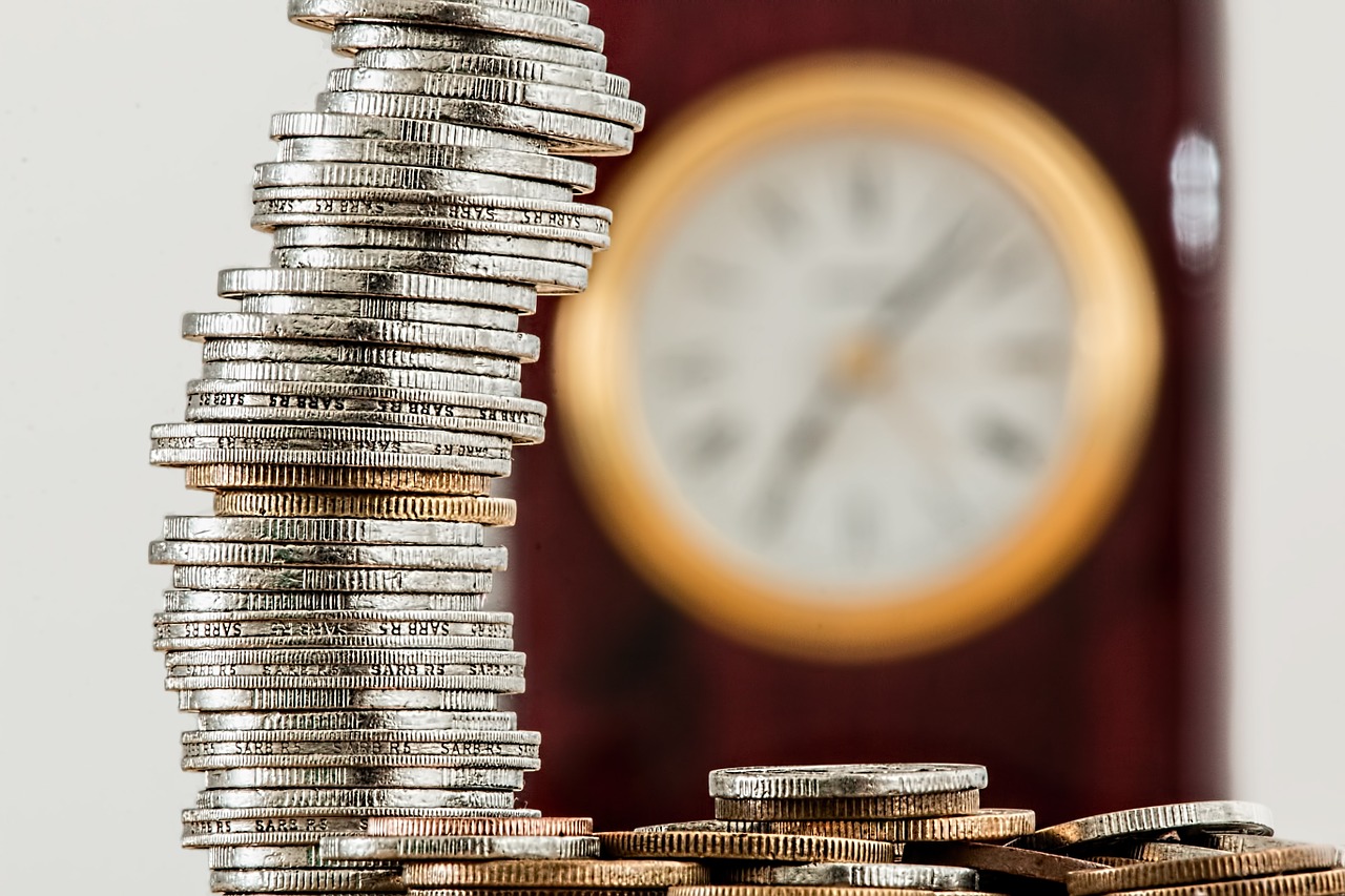 Five Ways to Manage a Healthy Cash Flow - a tower of coins with a clock in the background