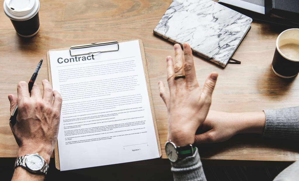 Advantages of digital signing - photo of contact on table with two people's hands, one holding a pen