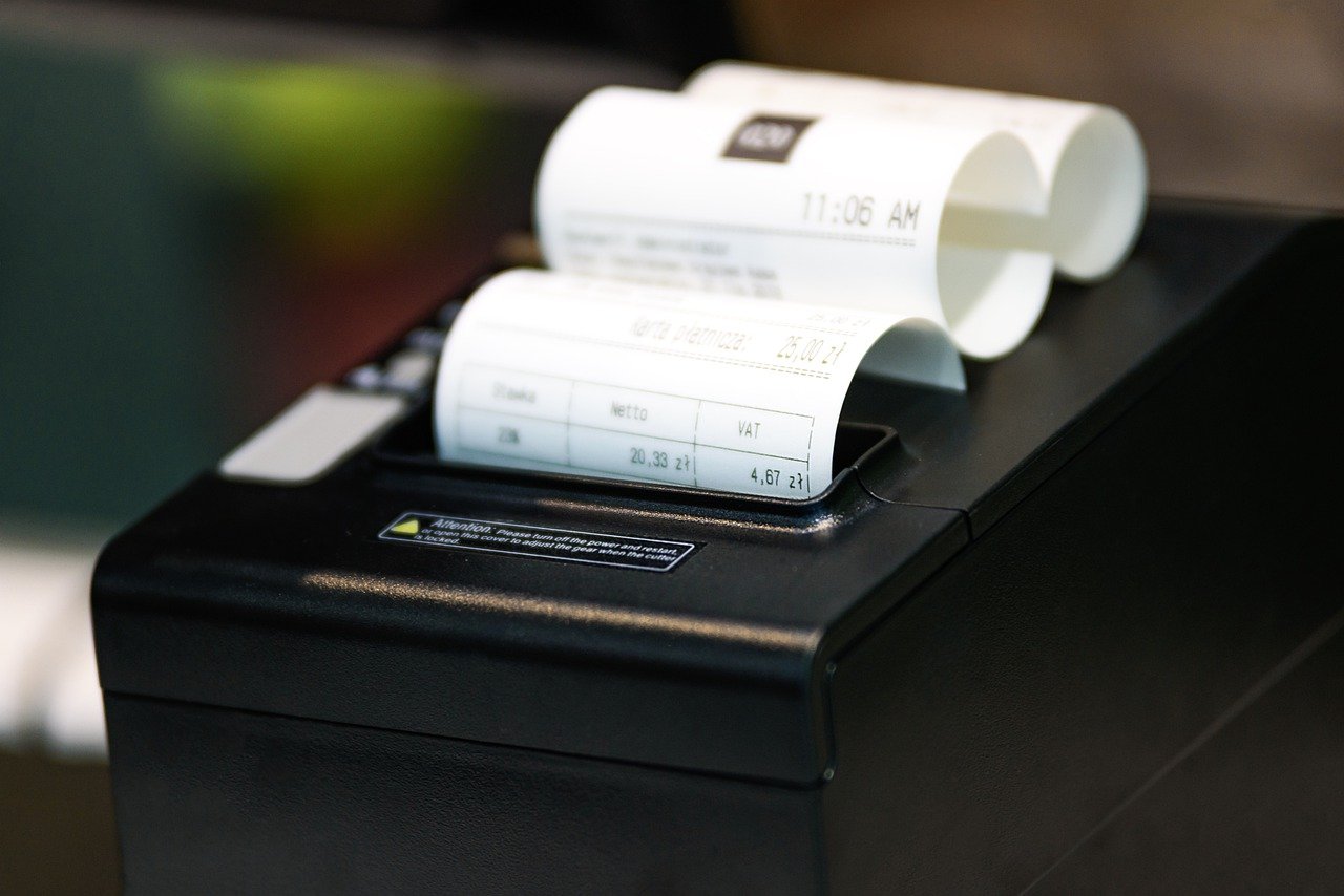 4 Reasons Your Business Should Consider Digital Receipts - a receipt printer with paper receipts