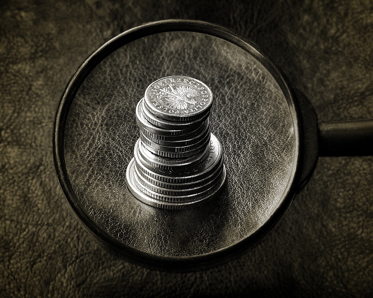 If my business is making a profit, where is the cash? - A small heap of coins viewed through a magnifying lens.