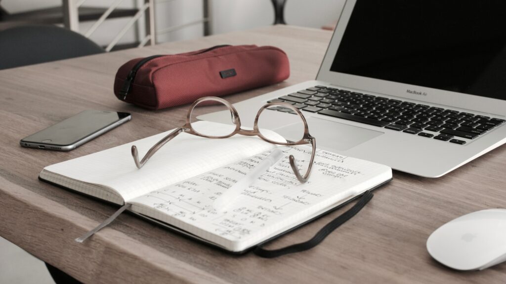 Financial best practices for small business - eyeglasses on book beside laptop