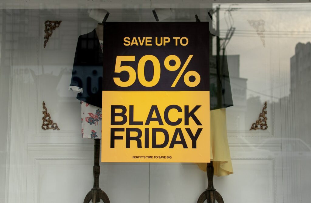 Business Update – 7 December 2023 - shop window sign "save up to 50% Black Friday"