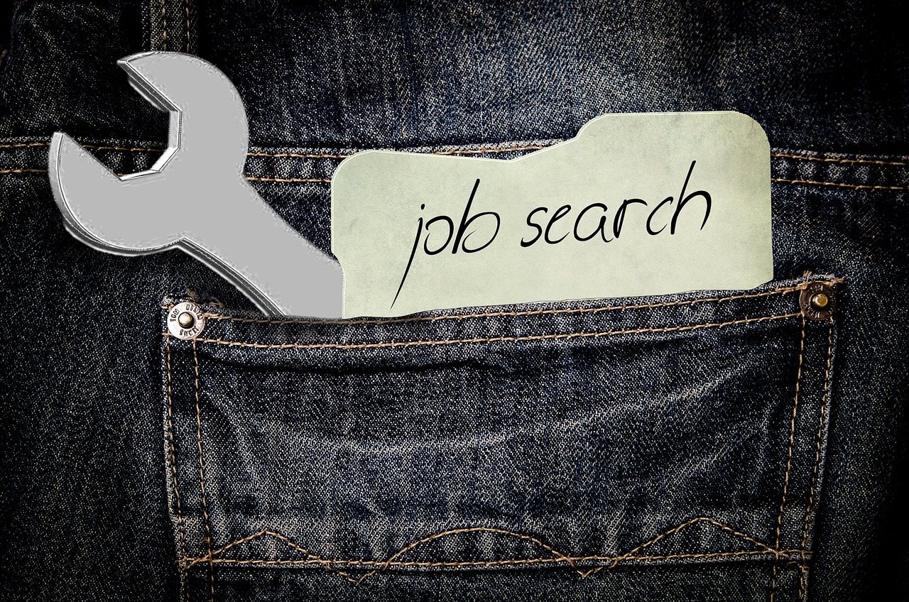 JobSeeker income-support payments changes - a spanner and slip of paper with the words "job search" in a jeans back pocket.