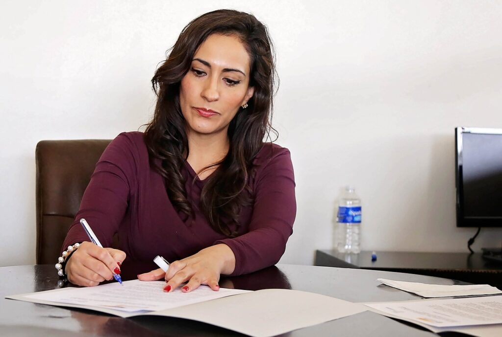 5 Strategies to Improve Financial Literacy for Women - a woman at a desk with paperwork