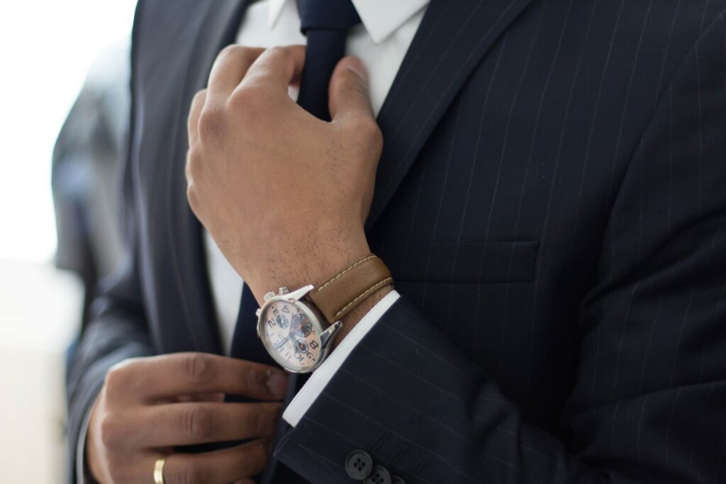 3 easy ways to look more professional when you’re starting out - man wearing watch with black suit